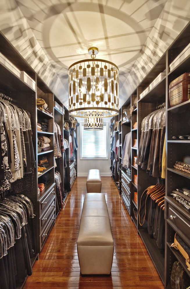 Inspiration for an expansive contemporary dressing room for men in Toronto with open cabinets, dark wood cabinets, dark hardwood flooring and brown floors.