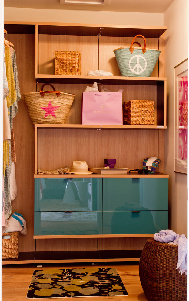 Contemporary gender neutral wardrobe in New York with flat-panel cabinets and blue cabinets.