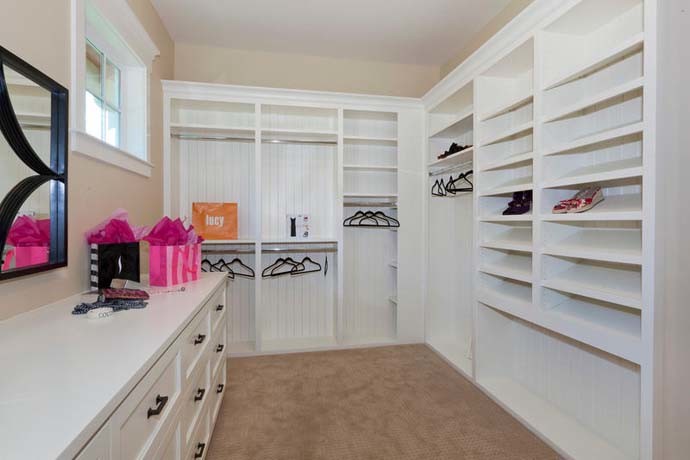 Example of a huge arts and crafts gender-neutral carpeted walk-in closet design in Seattle with white cabinets