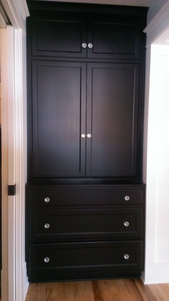 Photo of a large coastal walk-in wardrobe for men in Philadelphia with recessed-panel cabinets, white cabinets and medium hardwood flooring.