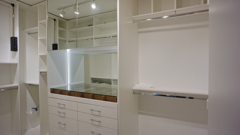 Foto de armario vestidor unisex clásico pequeño con armarios con paneles lisos, puertas de armario blancas y suelo de baldosas de porcelana