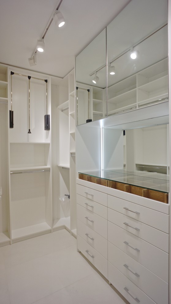 Small traditional gender neutral walk-in wardrobe in Miami with flat-panel cabinets, white cabinets and porcelain flooring.