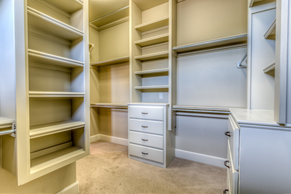 Design ideas for a large rustic gender neutral walk-in wardrobe in Oklahoma City with flat-panel cabinets, white cabinets and carpet.