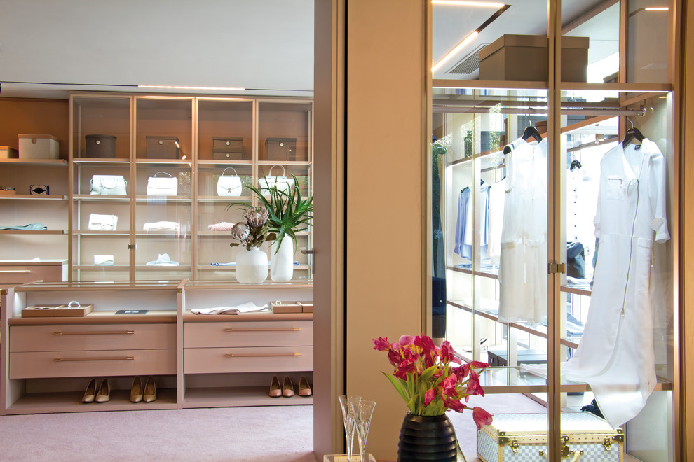 На фото: парадная гардеробная в современном стиле с плоскими фасадами, ковровым покрытием и розовым полом с