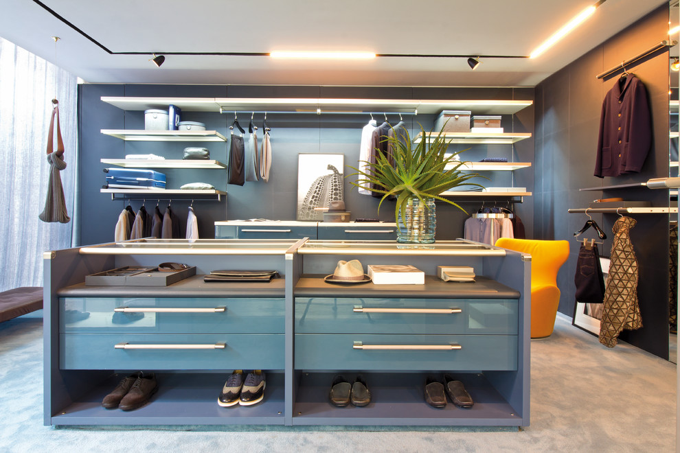 Modernes Ankleidezimmer mit Ankleidebereich, flächenbündigen Schrankfronten, blauen Schränken, Teppichboden und blauem Boden in Sonstige