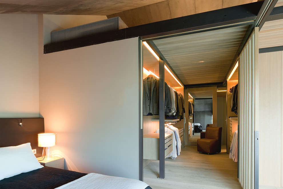 Foto di una grande cabina armadio unisex contemporanea con ante lisce, ante in legno chiaro, parquet chiaro e pavimento beige