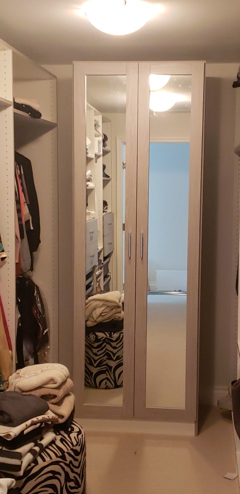 Example of a large minimalist gender-neutral walk-in closet design in Vancouver with flat-panel cabinets and gray cabinets