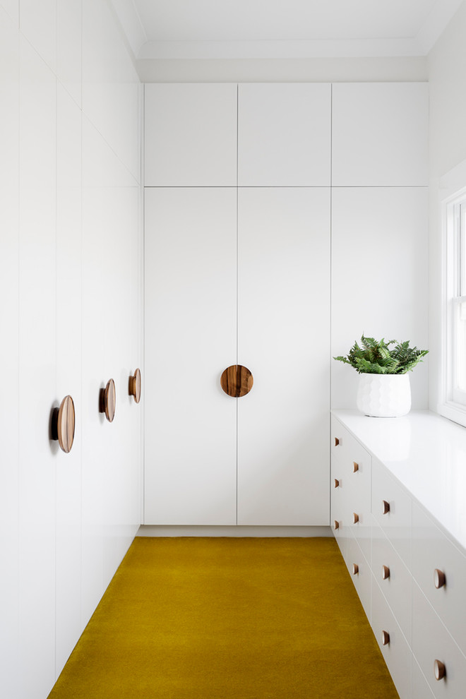 Идея дизайна: гардеробная комната среднего размера, унисекс в современном стиле с плоскими фасадами, белыми фасадами, ковровым покрытием и желтым полом