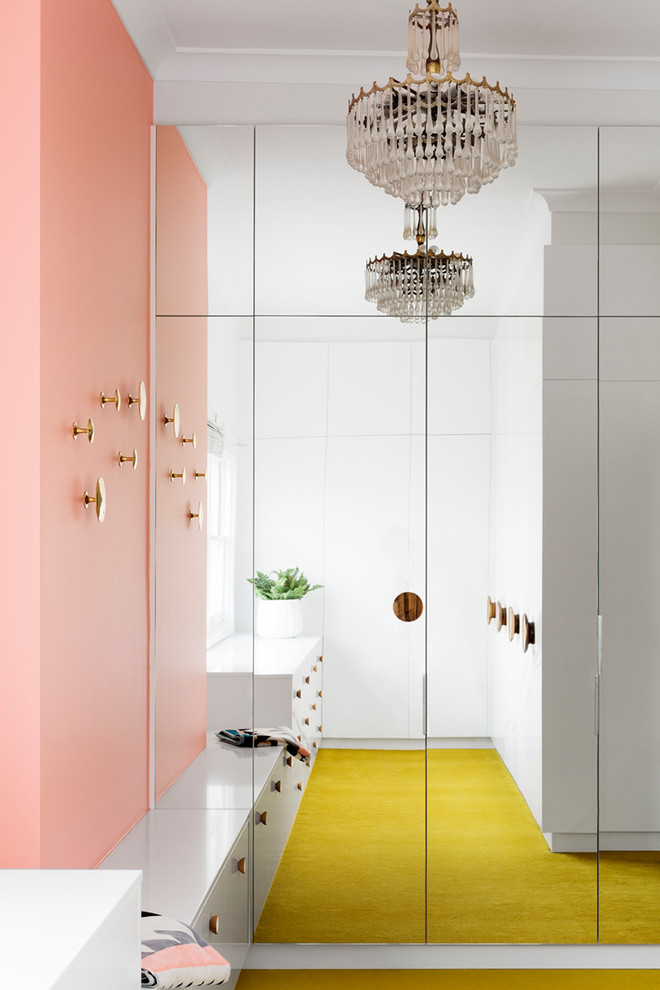 Idéer för att renovera ett mellanstort funkis walk-in-closet för könsneutrala, med släta luckor, vita skåp, heltäckningsmatta och gult golv