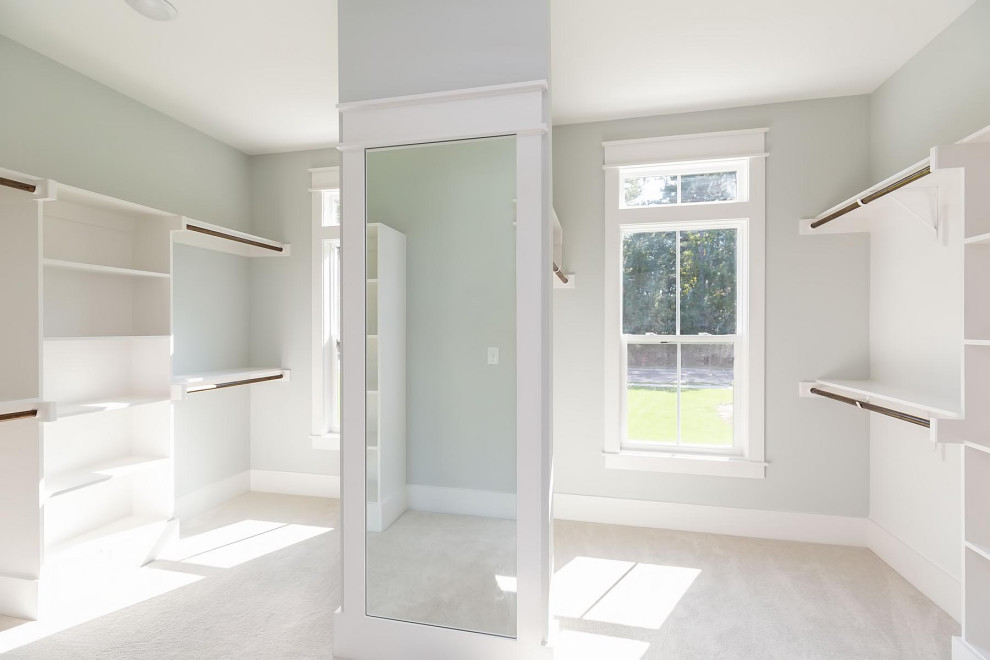 Стильный дизайн: большая гардеробная комната унисекс в классическом стиле с ковровым покрытием и серым полом - последний тренд