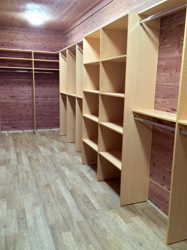 Ejemplo de armario vestidor unisex clásico grande con puertas de armario de madera clara y suelo de madera clara