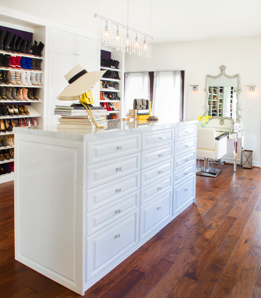 Inspiration for a large classic dressing room for women in Los Angeles with raised-panel cabinets, white cabinets and dark hardwood flooring.