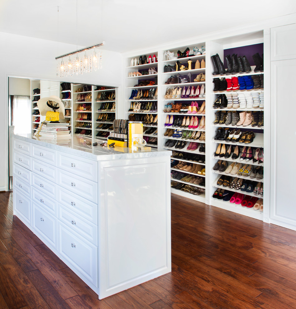 This is an example of a large classic dressing room for women in Los Angeles with raised-panel cabinets, white cabinets and dark hardwood flooring.