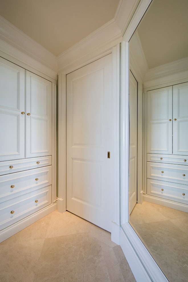 Foto di un armadio incassato unisex chic di medie dimensioni con ante bianche, pavimento con piastrelle in ceramica, pavimento beige e ante a filo