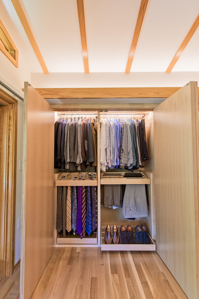 Imagen de armario de hombre de estilo americano de tamaño medio con armarios abiertos, puertas de armario de madera clara, suelo de madera clara y suelo beige