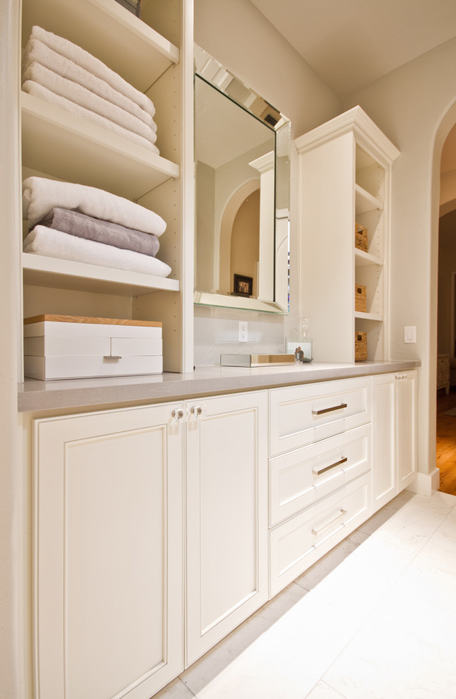 Inspiration pour un petit dressing room traditionnel neutre avec un placard avec porte à panneau encastré, des portes de placard beiges et un sol en carrelage de porcelaine.
