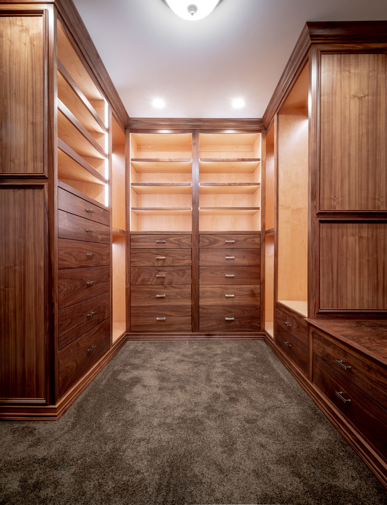 Inspiration for a large mediterranean gender-neutral carpeted and brown floor dressing room remodel in Indianapolis with flat-panel cabinets and dark wood cabinets