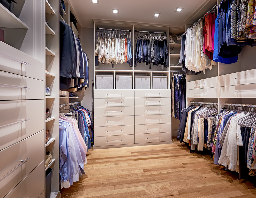 Imagen de armario vestidor unisex contemporáneo de tamaño medio con armarios con paneles lisos, puertas de armario grises y suelo de madera clara