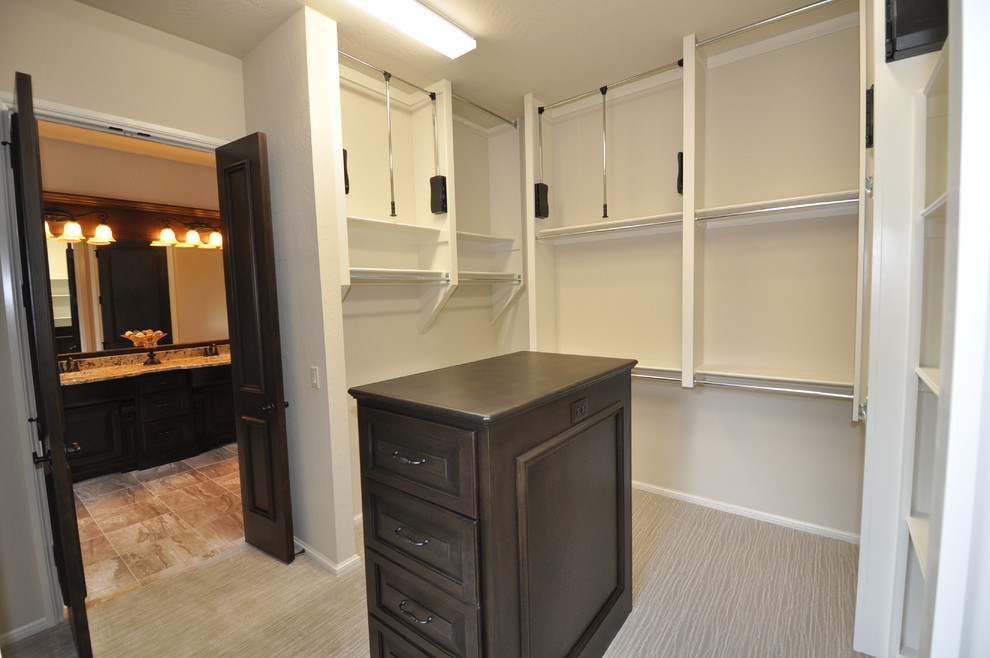 Exemple d'un très grand dressing room chic en bois brun neutre avec un placard avec porte à panneau surélevé et moquette.