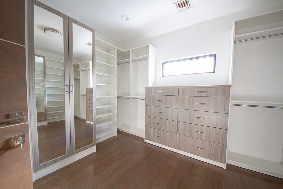 На фото: гардеробная комната среднего размера, унисекс в современном стиле с плоскими фасадами, светлыми деревянными фасадами и паркетным полом среднего тона с