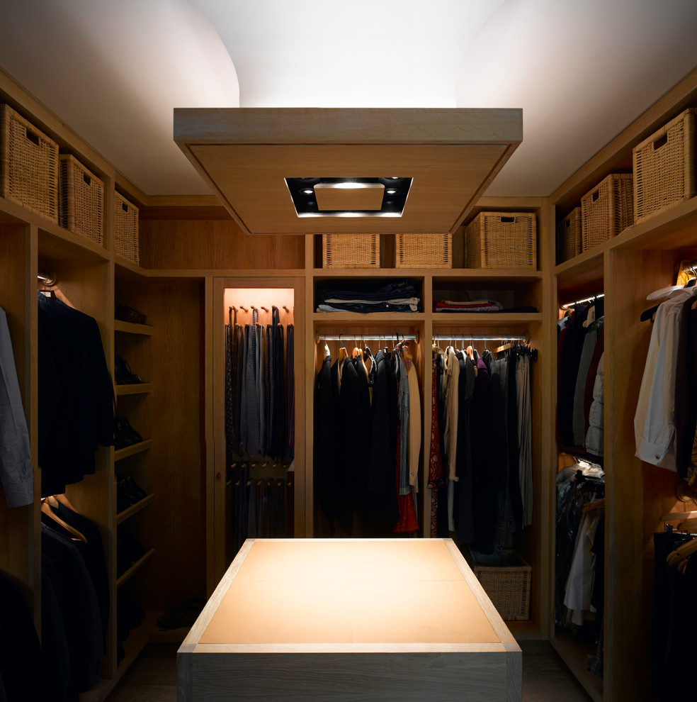 Diseño de armario vestidor unisex clásico renovado de tamaño medio con armarios abiertos, puertas de armario de madera clara y suelo de madera en tonos medios