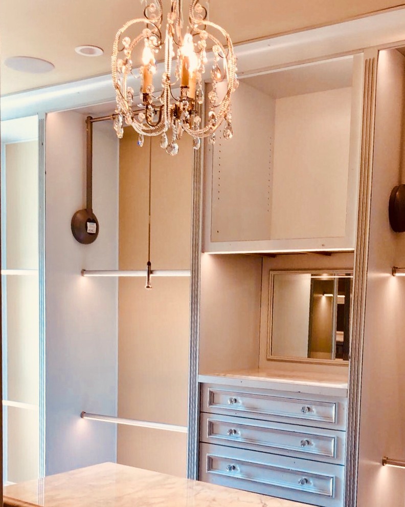 Imagen de armario vestidor unisex clásico renovado de tamaño medio con armarios con paneles empotrados, puertas de armario azules, suelo de madera oscura y suelo marrón