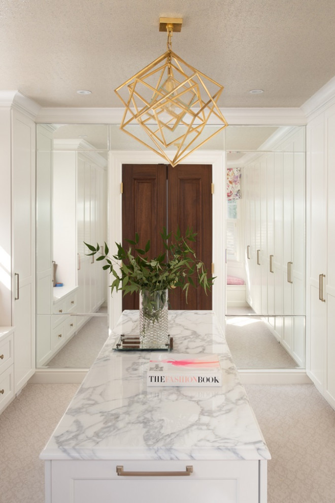 Large traditional dressing room for women in DC Metro with flat-panel cabinets, white cabinets, carpet and beige floors.