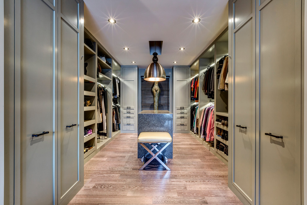 This is an example of a traditional gender neutral dressing room in Other with open cabinets and light hardwood flooring.