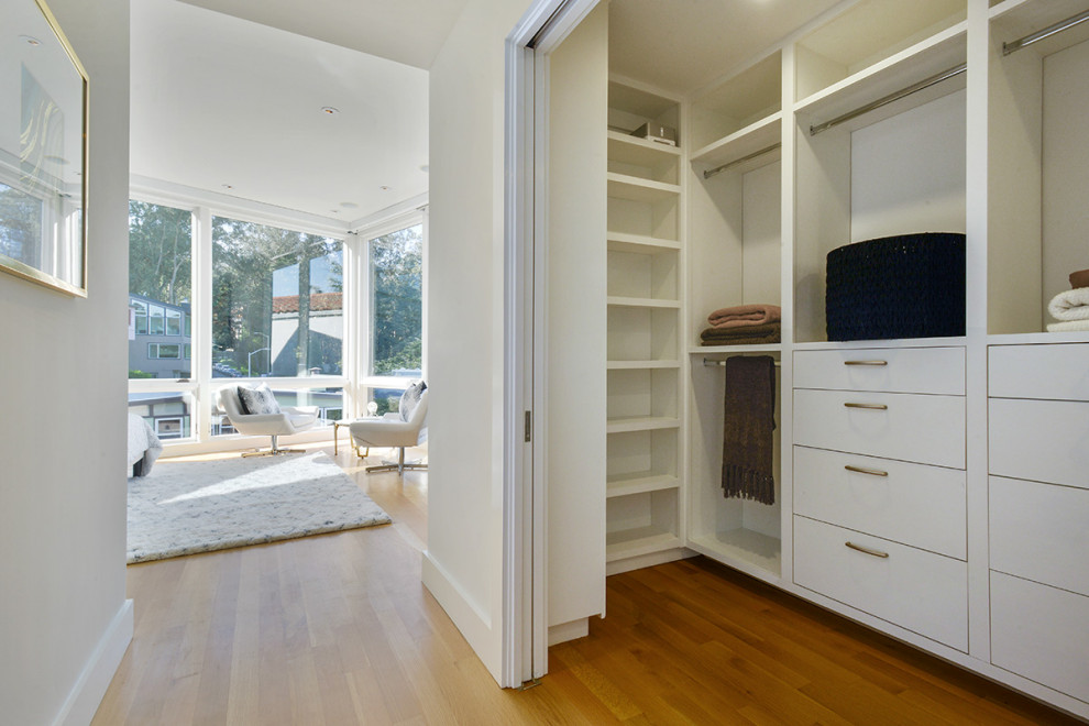 Источник вдохновения для домашнего уюта: гардеробная комната среднего размера, унисекс в стиле модернизм с плоскими фасадами, белыми фасадами, светлым паркетным полом и бежевым полом