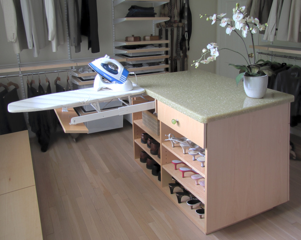 Diseño de armario vestidor unisex clásico de tamaño medio con armarios con paneles lisos, puertas de armario de madera clara, suelo de madera clara y suelo beige