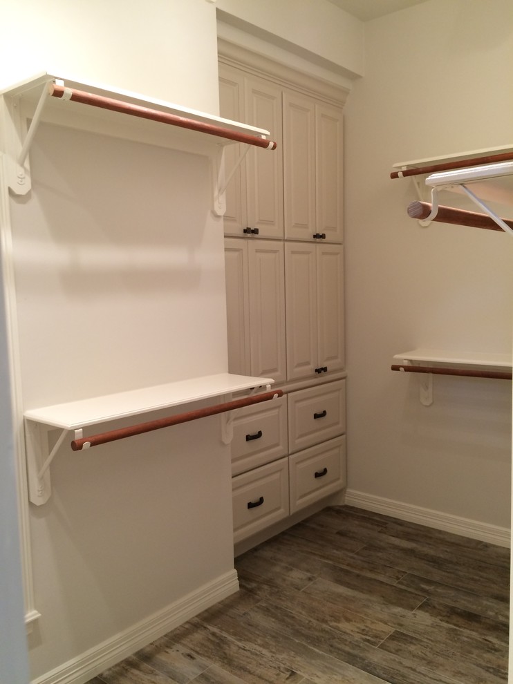 Design ideas for a traditional walk-in wardrobe in Houston with white cabinets.