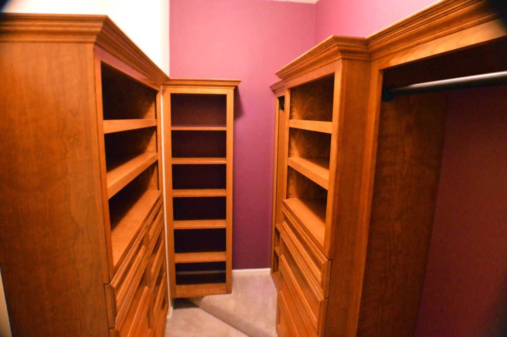 Diseño de armario vestidor unisex clásico grande con armarios abiertos, puertas de armario de madera oscura y moqueta