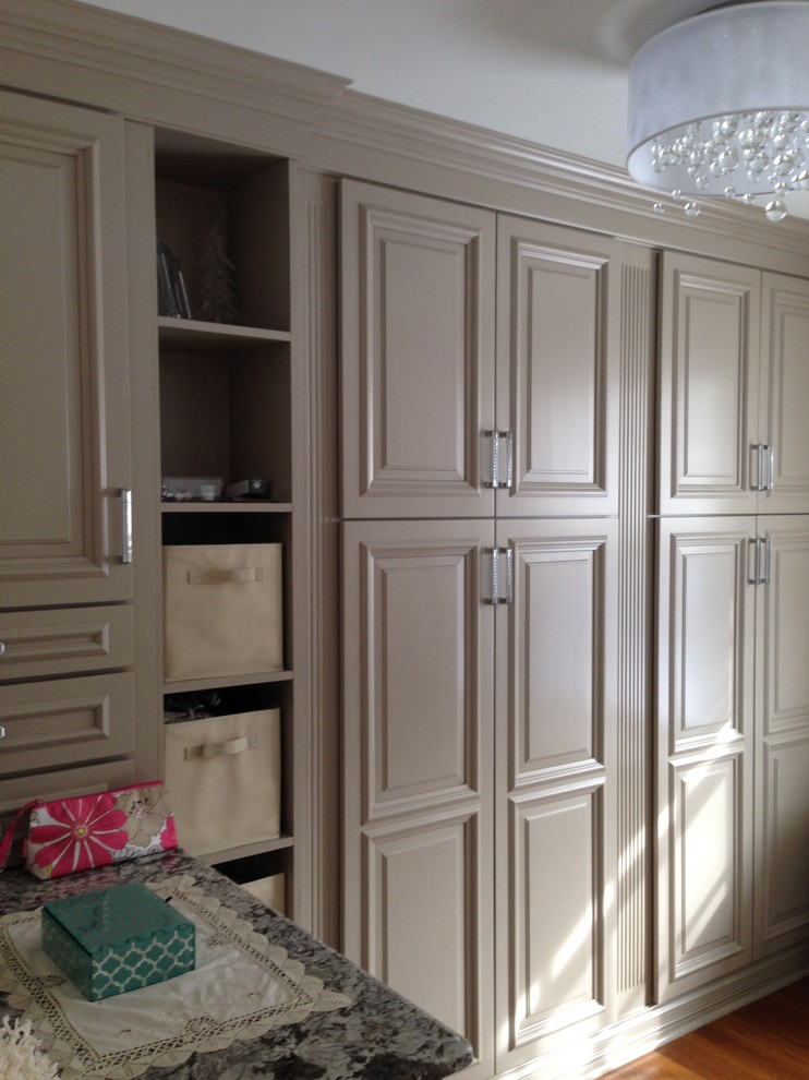 Mid-sized elegant women's medium tone wood floor dressing room photo in New York with raised-panel cabinets and gray cabinets