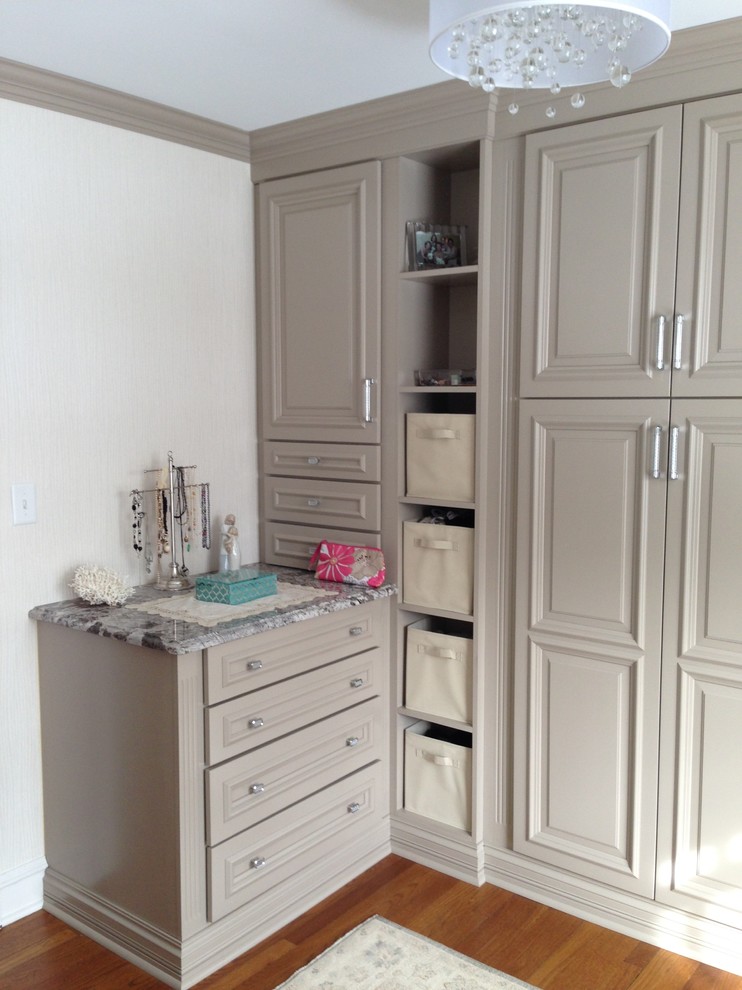 Inspiration for a mid-sized timeless women's medium tone wood floor dressing room remodel in New York with raised-panel cabinets and gray cabinets