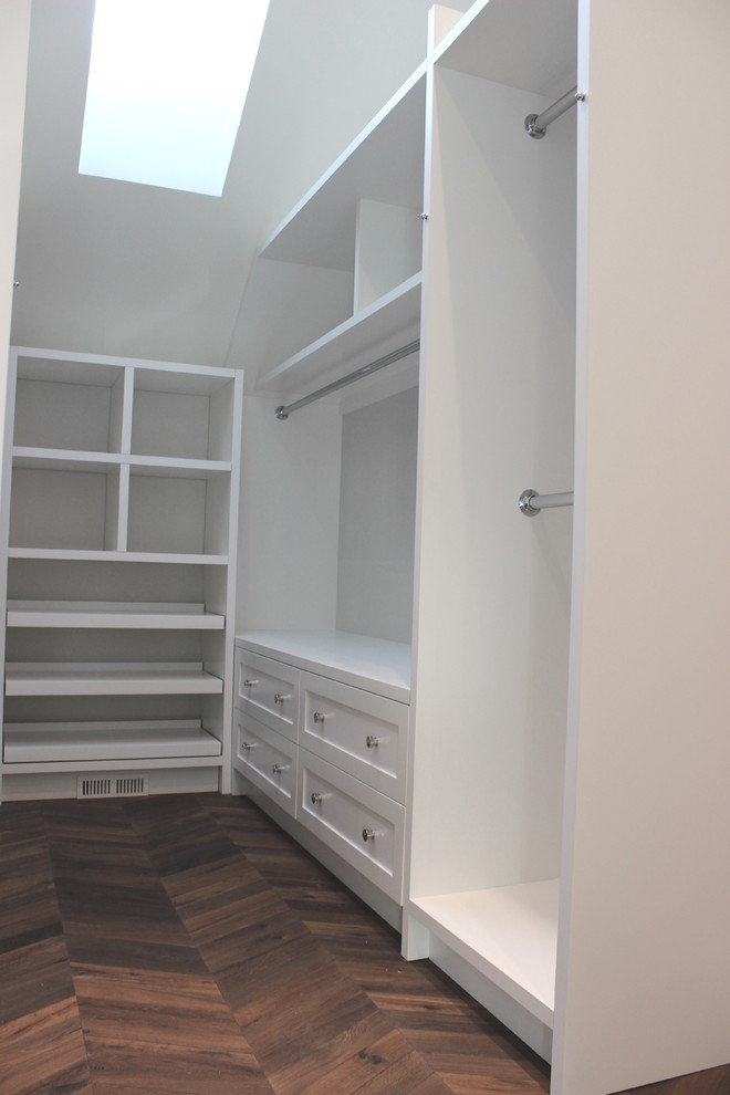 Immagine di una cabina armadio unisex chic di medie dimensioni con ante in stile shaker, ante bianche e pavimento in legno massello medio