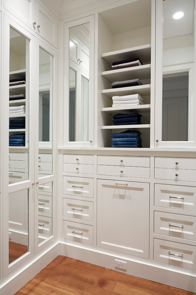 Стильный дизайн: гардеробная комната унисекс в стиле кантри с белыми фасадами и паркетным полом среднего тона - последний тренд