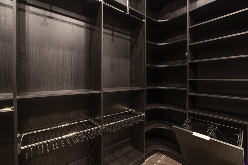 Imagen de armario vestidor actual grande con armarios con paneles lisos y puertas de armario negras