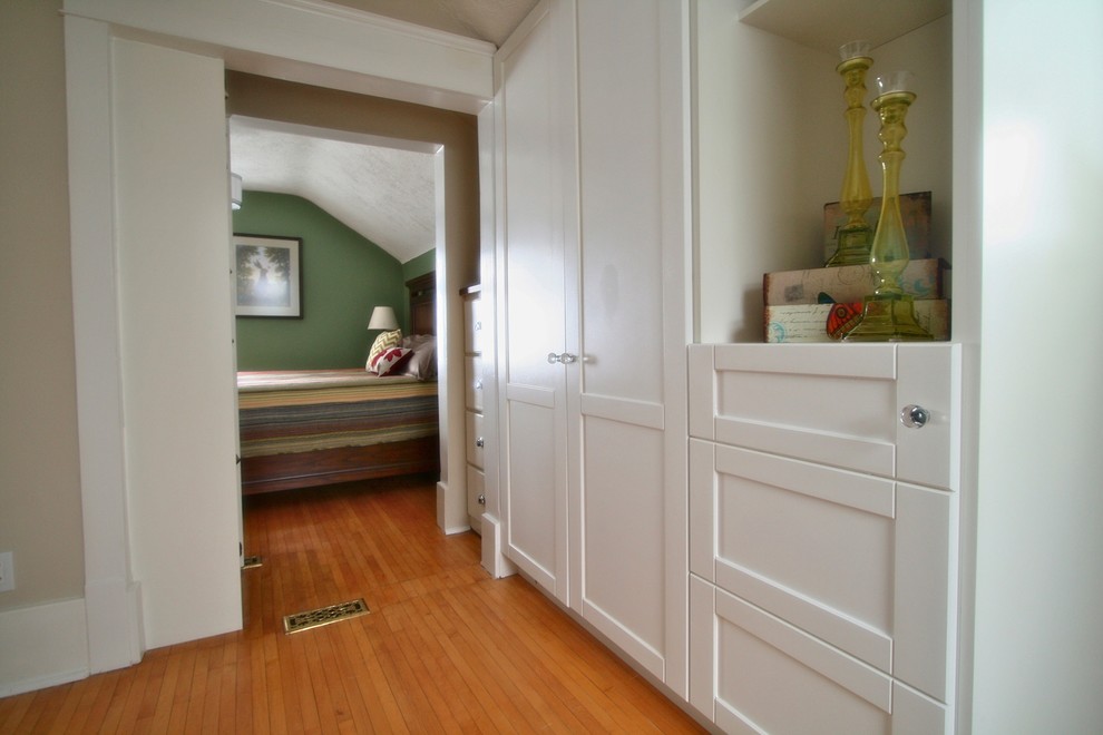 Immagine di uno spazio per vestirsi unisex classico di medie dimensioni con ante in stile shaker, ante bianche e pavimento in legno massello medio
