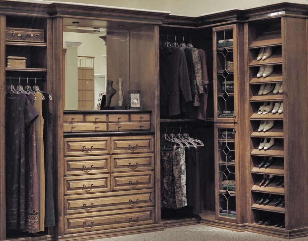 Ejemplo de armario vestidor unisex clásico de tamaño medio con armarios tipo vitrina, puertas de armario de madera oscura y moqueta