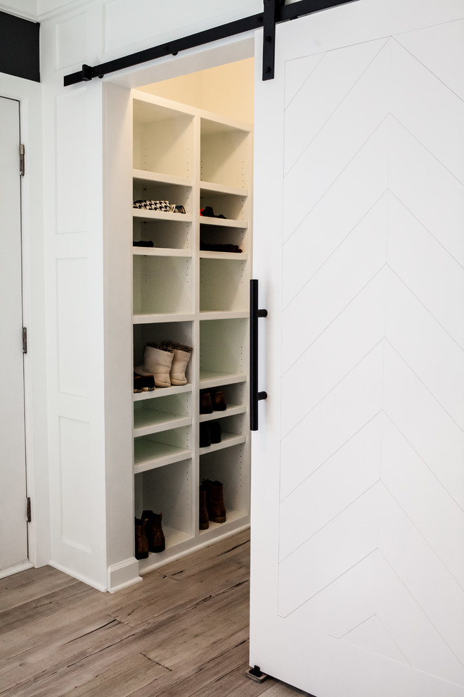 Foto di un piccolo armadio o armadio a muro unisex classico con pavimento in legno massello medio, nessun'anta, ante bianche e pavimento marrone