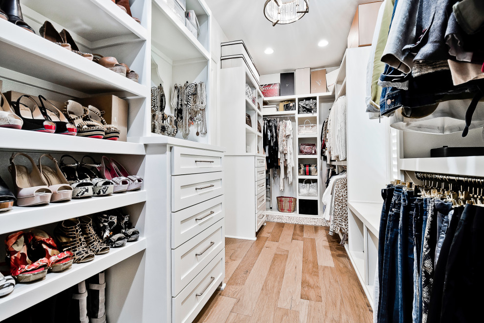 Idéer för att renovera ett stort vintage walk-in-closet för kvinnor, med luckor med infälld panel, vita skåp och ljust trägolv