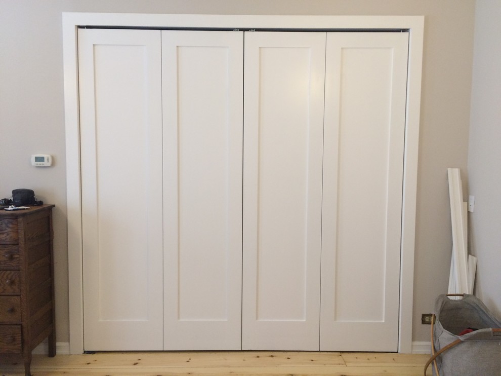 Idées déco pour un placard dressing classique avec un placard à porte shaker, des portes de placard blanches et parquet clair.