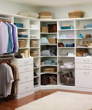 Imagen de armario vestidor unisex clásico de tamaño medio con armarios con paneles lisos, puertas de armario blancas, suelo de madera oscura y suelo marrón