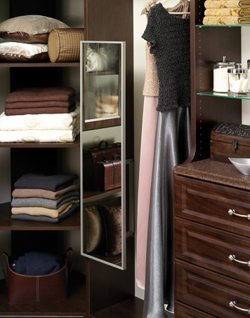 Inspiration for a mid-sized transitional gender-neutral carpeted and beige floor walk-in closet remodel in Jacksonville with raised-panel cabinets and dark wood cabinets
