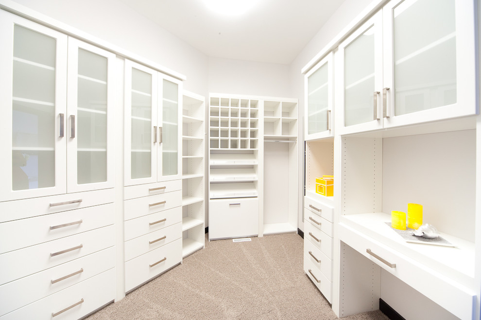 Design ideas for a large contemporary gender neutral walk-in wardrobe in Other with white cabinets, carpet and glass-front cabinets.
