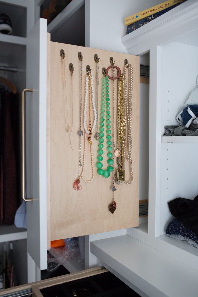 Imagen de armario vestidor unisex minimalista pequeño con armarios con paneles lisos, puertas de armario blancas, suelo de madera clara y suelo multicolor