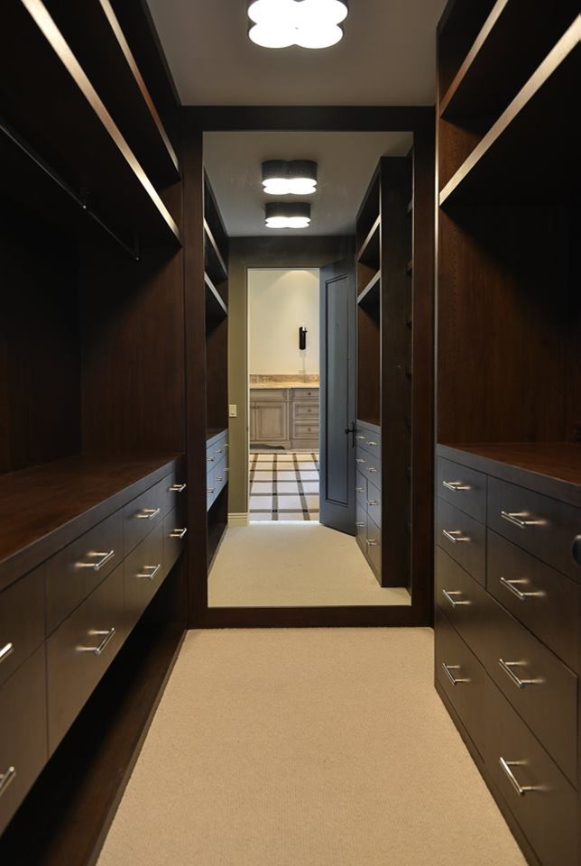 Design ideas for a small modern walk-in wardrobe in Phoenix with flat-panel cabinets, dark wood cabinets and carpet.