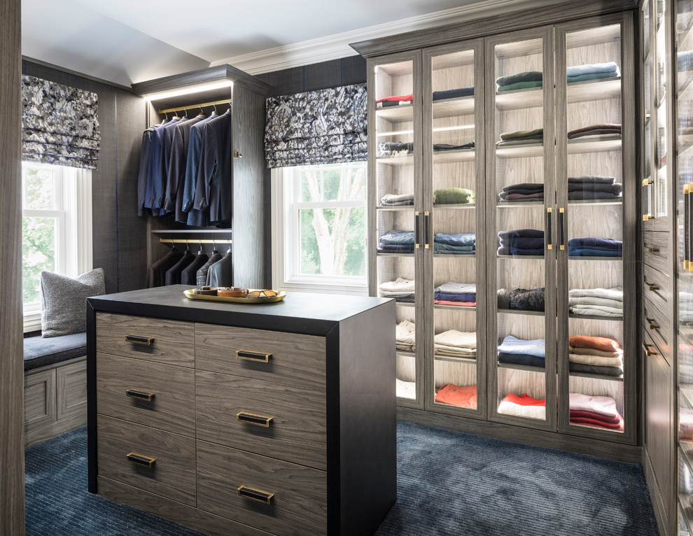 Transitional men's carpeted and blue floor walk-in closet photo in New York with glass-front cabinets