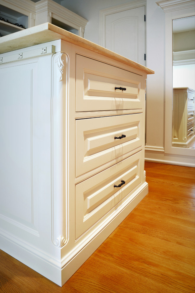 Modelo de armario vestidor unisex clásico de tamaño medio con armarios con paneles con relieve, puertas de armario blancas y suelo de madera en tonos medios