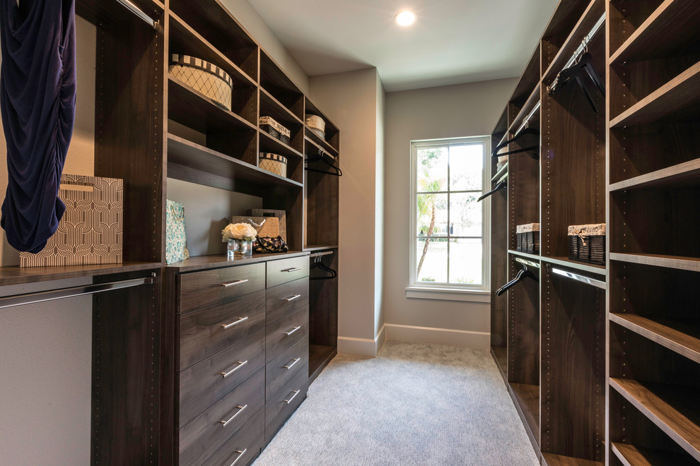 На фото: гардеробная комната среднего размера, унисекс в стиле кантри с плоскими фасадами, темными деревянными фасадами и ковровым покрытием